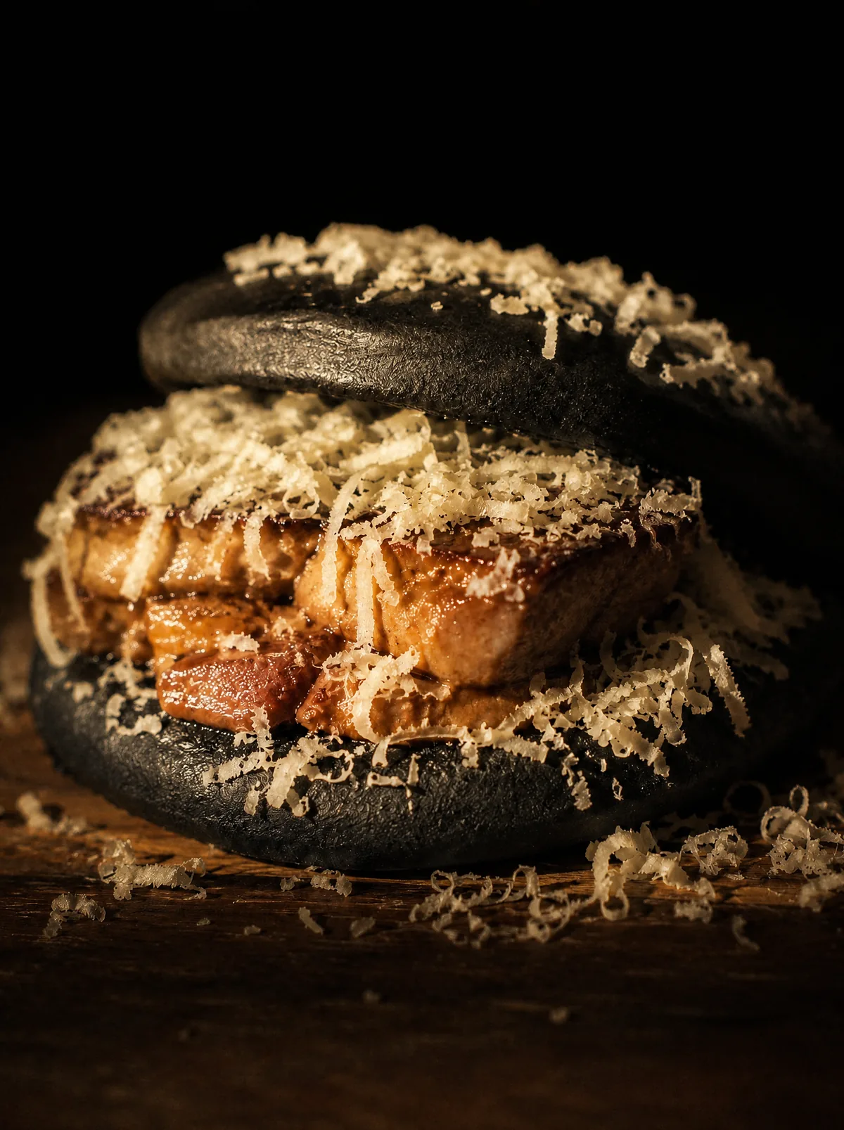 Bocado de pan negro con panceta melosa y queso curado rallado